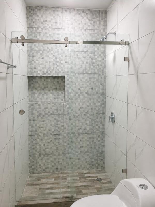 Mampara de ducha de vidrio templado con perfil cromado en baño moderno